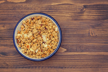 granola with nuts in the bowl on wooden background