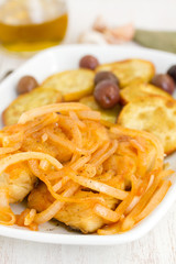 fried cod fish with onion and olive oil on dish