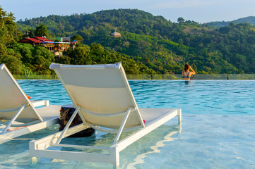 Luxury swimming pool with sunbeds in water at the resort with beautiful landscape view