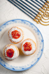 Donuts with jam on a plate with a blue rim and Hanukkah closeup