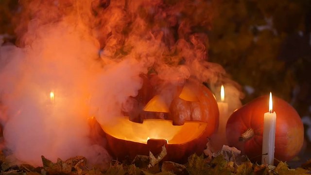 Pumpkins and candles in the smoke. Halloween concept