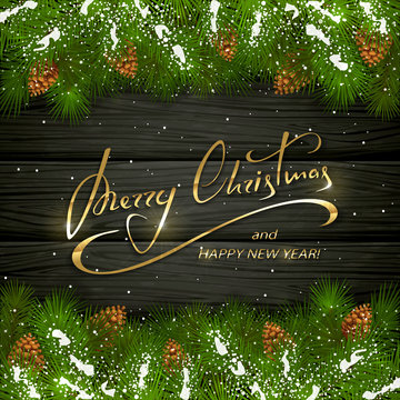 Merry Christmas on black wooden background with fir tree branches and snow