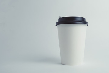 Mockup image of paper cup with cap on clean bacground