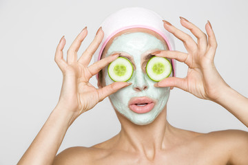 Beautiful blonde woman with a facial mask, beauty spa