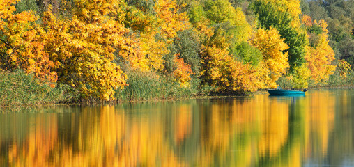 Autumn trees and their reflection in the water of the river