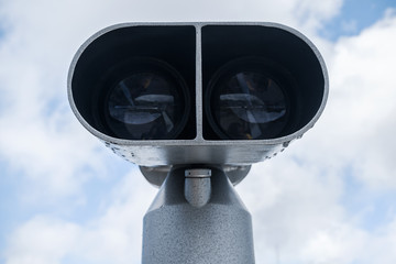 Tourist binocular telescope over cloudy sky