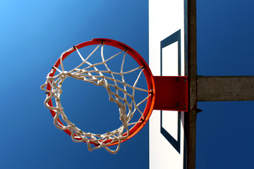 Basketball rim (hoop) seen from below against clear blue sky