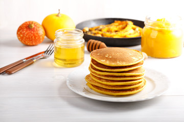 Stack of homemade pumpkin pancakes on white table