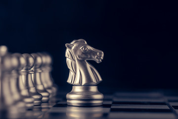 Chess on a chessboard at black background, Business leader concept. vintage tone.