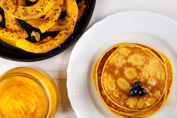 Different dishes of pumpkin. Baked slices of pumpkin, pancakes and puree.