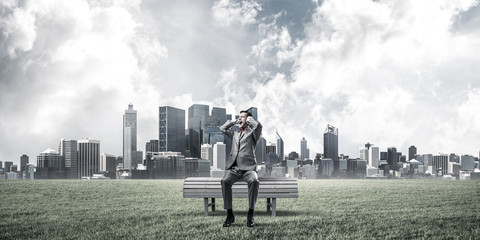 Young man in suit in park dont want to hear anything