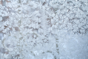 Frosty pattern on window glass with strips and fantastic snowflakes.