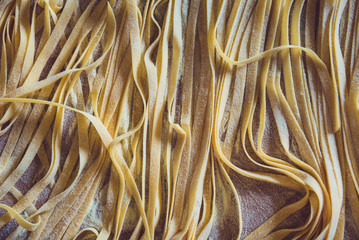 Wooden board full of fresh raw homemade pasta