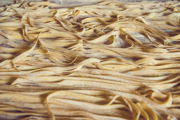 Wooden board full of fresh raw homemade pasta