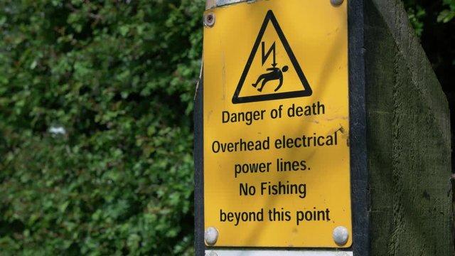 Danger of death, overhead electrical power lines sign along canal in Staffordshire, England.