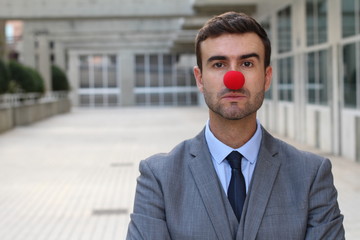 Businessman with a red clown nose isolated 