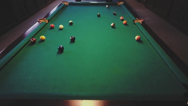 American billiard. Man playing billiard, snooker. Player preparing to shoot, hitting the cue ball.