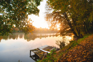 Autumn foliage lake in morning with pier