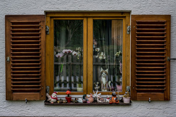 Wooden window lovely decorates with ceramic figurines of cats and snails  