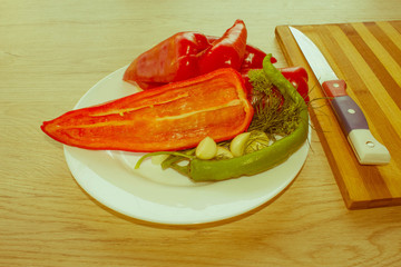 Plate with fresh vegetables on table. Green and red bell pepper