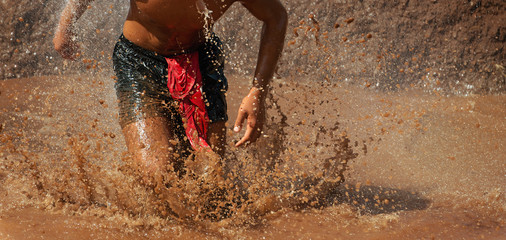 Mud race runners obstacle race runner in action