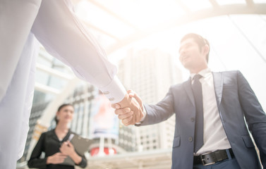 handshake of business People Colleagues Teamwork Meeting .Hold hand and shake hand in city building...