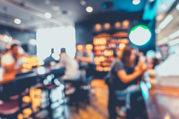 Fototapeta na wymiar Blurred background of customer sitting in coffee shop or cafe restaurant with bokeh light