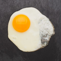 Fried egg isolated on black background top