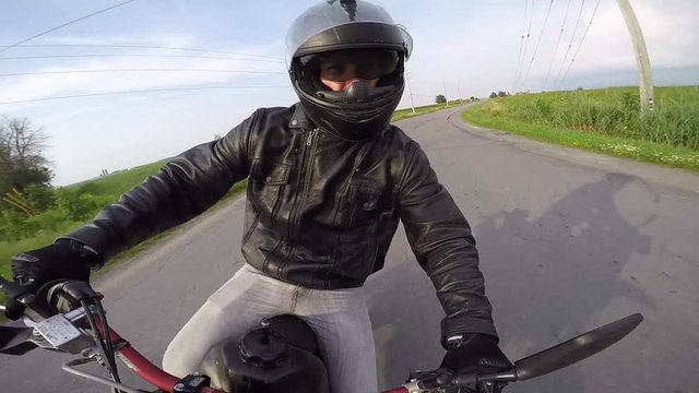 motorcycle rider gives devils horn signal then takes corner gopro swivel