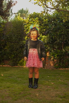 Child dressed up as a rocker with leader jacket and star earings. Outdoor