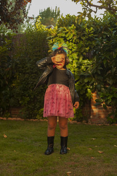 Child dressed up as a rocker with leader jacket covering eyes. Sunset