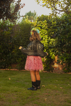 Rear view girl dressed up as a rocker with leader jacket. Outdoor