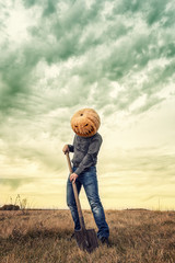 Modern Jack-lantern with  pumpkin on his head and shovel.
