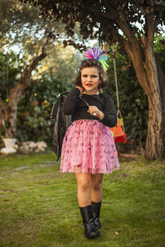 Portrait child dressed as a rocker with star earings. Garden