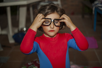 Portrait child dressed with spiderman costume and glasses accesory.