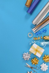 gift wrapping utensils in wintery colors on cyan background