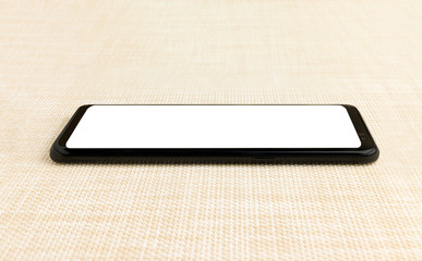 Black smart phone with white screen on the wooden table