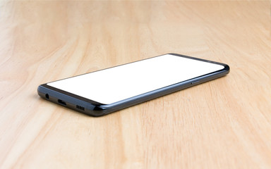 Black smart phone with white screen on the wooden table