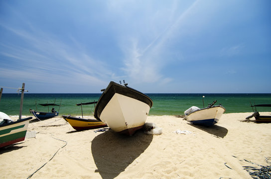 Beautiful scenery, traditional fisherman boat moored over beautiful sea view and sandy beach under bright sunny day
