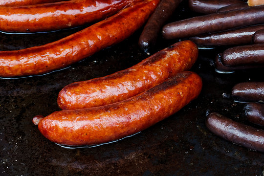 Paprika bratwurst sausages on cast iron griddle.