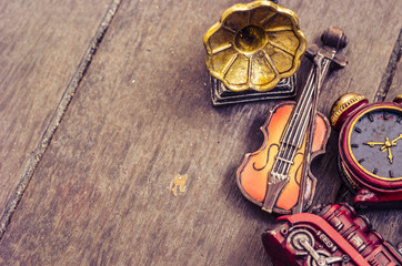 hobby and leisure object concept, miniature violin, clocks, train and gramaphone on wooden floor
