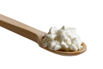 Chunky cottage cheese on wooden spoon isolated on white.
