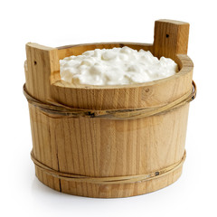 Chunky cottage cheese in rustic wood container isolated on white.