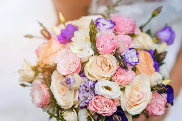 bridal bouquet of bride in the rays of sunlight, engagement rings lie on flowers