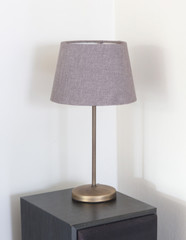 Table lamp standing on a large speaker