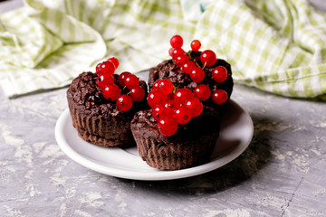 chocolate muffin with redcurrant on white. healthy dessert