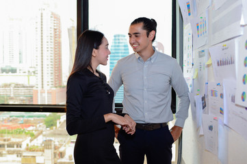 smile of business man and business woman stand and talk about business at the office