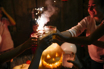 Group of friends in the party with pumpkin, candies and soft drinks