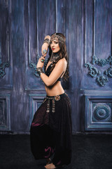 Beautiful woman dancer dancing belly dance in oriental style. Traditional Indian dance in traditional oriental image and costume with oriental ornaments decorations