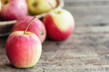 Stack of fuji apple and in basket put on wood table for background or wallpaper in vintage tone style. Delicious sweet and juicy fuji apple for salad cooking or bakery.Fuji apple has origins in Japan.